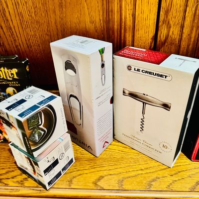 Sale Photo Thumbnail #14: Collection of boxed barware and kitchen accessories, including a Le Creuset antique chrome traditional corkscrew and a Vinturi wine opener, displayed alongside small boxed gift items.