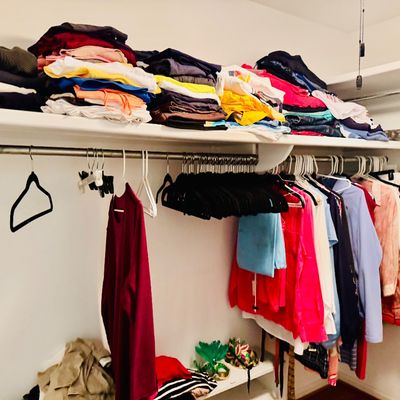 Sale Photo Thumbnail #70: Closet filled with folded tops, t-shirts, and sweaters on upper shelving above hung shirts, jackets, and empty hangers.