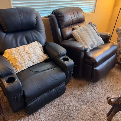 Pair of dark brown leather power recliners with built-in cupholders and textured accent pillows.