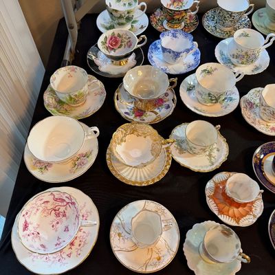 Collection of vintage bone china teacups and matching saucers featuring diverse floral, gilded, and hand-painted designs.