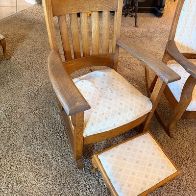 Antique Mission Arts and Crafts style quarter-sawn oak rocking chair with slatted back, wide armrests, and matching padded footstool.