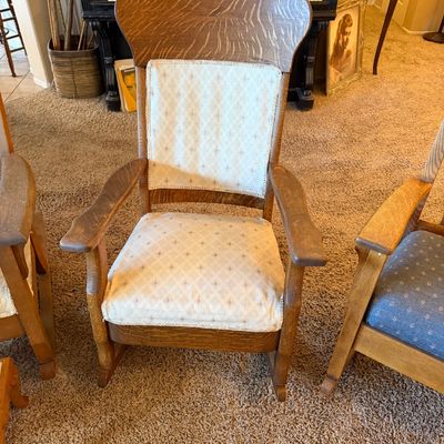 Antique quarter-sawn oak rocking chair featuring a contoured high back with tiger oak grain and cream patterned fabric upholstery.