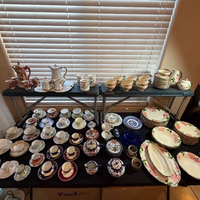 Large collection of vintage fine china, including tea cups, saucers, teapots, and Franciscan Desert Rose dinnerware displayed on tables.