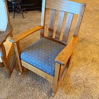 Antique Mission Arts and Crafts quarter-sawn oak rocking chair featuring a slatted back, wide armrests, and a blue pattern-upholstered...