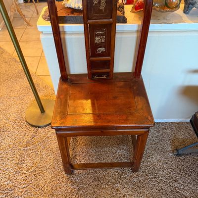 Traditional Asian-style carved wooden chair featuring inlaid seal script characters along the central back splat.