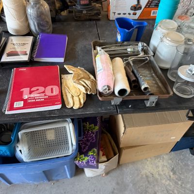 Assorted workshop items, office supplies, and household goods, including power tools, paint rollers, notebooks, leather work gloves, and...