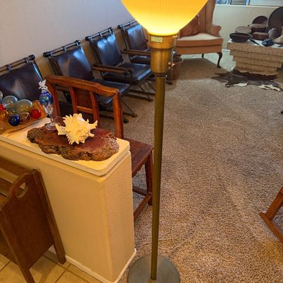 Mid-century torchiere floor lamp with a brass pole and a yellow frosted glass shade.
