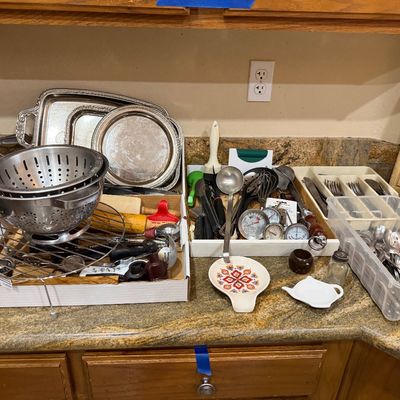 Assortment of vintage kitchenware and utensils, including silver-plated serving trays, stainless steel colanders, meat thermometers, and...