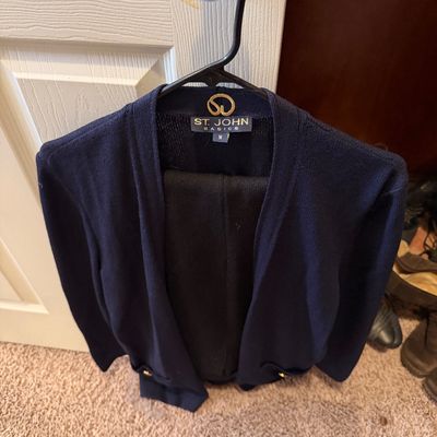 St. John Basics navy blue Santana knit jacket or cardigan, size medium, hanging on a door handle.
