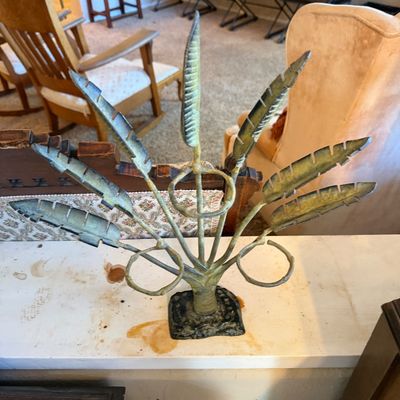 Decorative verdigris metal feather sculptural piece featuring stylized leaf or feather motifs radiating from a central stem with ring...