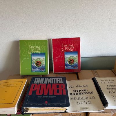 Collection of self-improvement, hypnosis, and Qigong books and manuals, including Unlimited Power and Spring Forest Qigong materials.