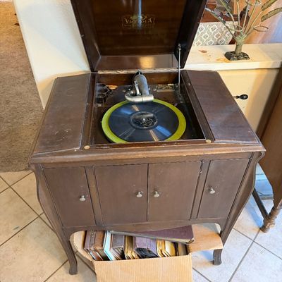 Antique Victor Talking Machine Co. Victrola floor model phonograph cabinet in dark wood, complete with record player, hand crank, and a...