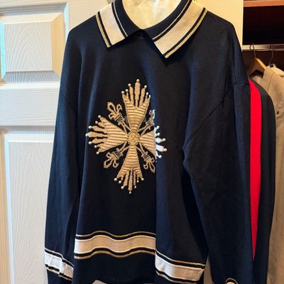 Vintage black long-sleeve knit sweater featuring an ornate beaded and embroidered cross graphic on the front, striped polo collar, and...