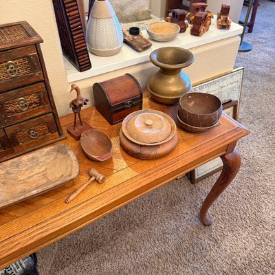 A collection of wooden and brass home decor, including hand-carved wooden bowls, a small chest, a mini wooden gavel, and a brass vase,...