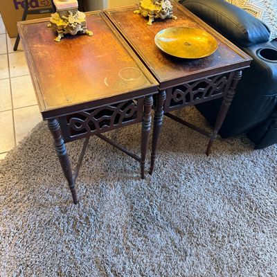 Pair of vintage traditional-style wooden end tables featuring fretwork aprons and turned, stretchered legs, showing significant finish...