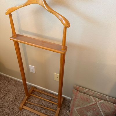 Vintage light oak gentleman's valet stand featuring a contoured coat hanger, top tray, trouser bar, and lower shoe rack.