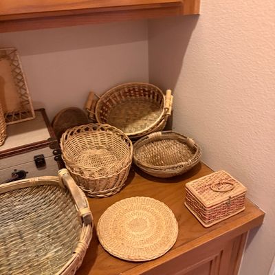 Collection of woven wicker and rattan items, including shallow bowls, a small lidded box, and a trivet.