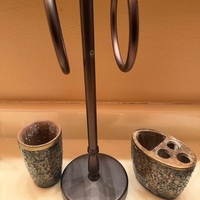 Sale Photo Thumbnail #107: Bronze-tone metal countertop hand towel stand accompanied by a matching mosaic-patterned tumbler and toothbrush holder.