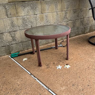 Sale Photo Thumbnail #125: Small outdoor patio side table featuring a round glass insert top and a dusty rose metal frame.