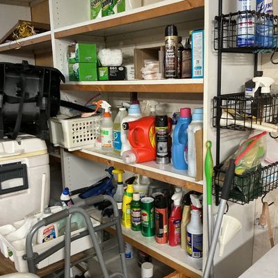 Sale Photo Thumbnail #128: Shelving unit fully stocked with household cleaning supplies, laundry detergents, paper towels, and mobility aids.