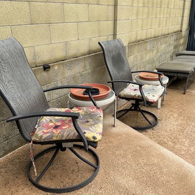 Sale Photo Thumbnail #124: Set of outdoor patio furniture including two swivel rocker armchairs with floral seat cushions, small round side tables, and a matching lounge chair.