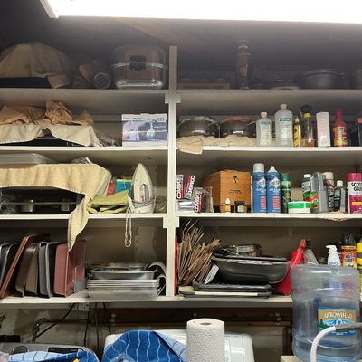 Sale Photo Thumbnail #132: White shelving unit filled with household supplies, small appliances, bakeware, and cleaning products.