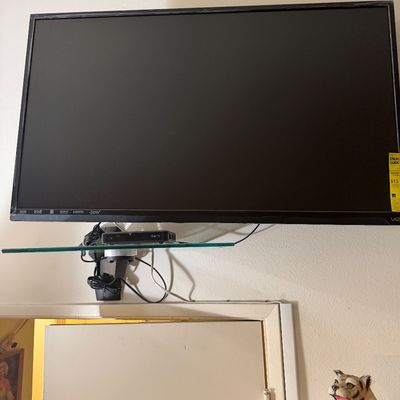 Sale Photo Thumbnail #120: Wall-mounted Vizio flat-screen television with slim black bezel, paired with a floating glass component shelf below.