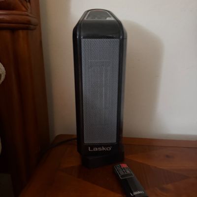 Sale Photo Thumbnail #116: Black Lasko ceramic tower space heater with digital control panel and matching remote control.