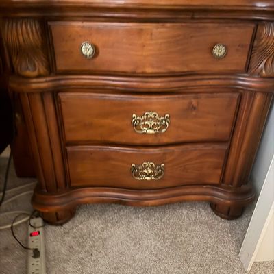 Sale Photo Thumbnail #118: Traditional wooden nightstand featuring a warm cherry finish, carved acanthus leaf details, and ornate brass hardware across three drawers.