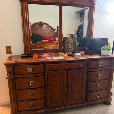 Sale Photo Thumbnail #122: Traditional French Provincial style wood dresser with an attached large split mirror frame, ornate brass handles, and a central cabinet with double doors.