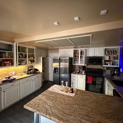 Spacious modern kitchen featuring white raised-panel cabinetry, granite countertops, and stainless steel appliances.