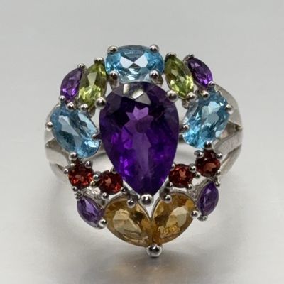 Silver cluster ring featuring a teardrop amethyst center stone surrounded by multi-colored gemstones, including topaz, peridot, and citrine.