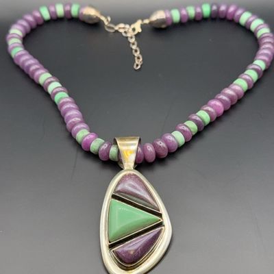 Southwestern-style sterling silver necklace featuring purple and light green beaded strands and a matching inlay pendant.