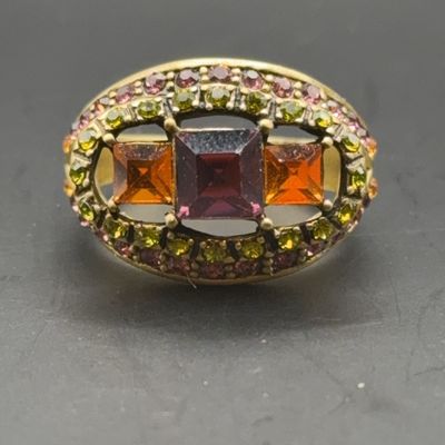 Vintage statement ring featuring square-cut purple and amber rhinestones framed by green and pink pavé stones in an antiqued gold-tone...