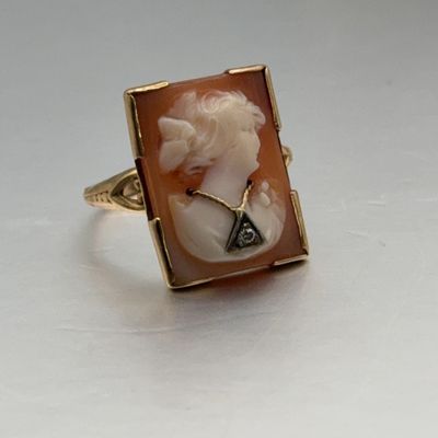 Vintage gold rectangular shell cameo ring featuring a carved profile of a woman embellished with a small diamond necklace accent.