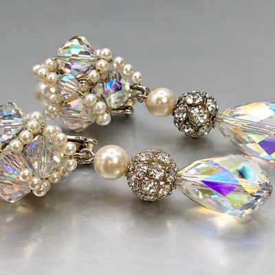 Pair of vintage crystal aurora borealis and faux pearl dangling clip-on earrings, featuring rhinestones and faceted glass teardrops.