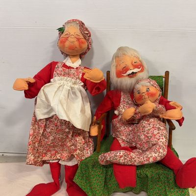 Set of vintage Annalee style cloth Christmas figures featuring Mrs. Claus standing alongside Santa Claus holding a child in a wooden...