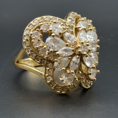 Gold-tone cluster ring featuring marquise- and round-cut cubic zirconia or crystals arranged in a floral statement design.