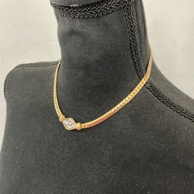 Sale Photo Thumbnail #218: Vintage gold-tone herringbone flat chain collar necklace featuring a central diamond-shaped focal point set with clear triangular rhinestones. Stamped S.A.L. © on the back (Swarovski America Limited mark used circa late 1970s to 1980s). Features a fold-o