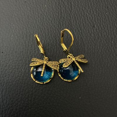 Sale Photo Thumbnail #190: Pair of gold-tone leverback drop earrings featuring a dragonfly accent seated atop round teal-blue glass cabochons. Total length is approximately 35 mm (1.4 inches). Good condition with minor surface wear on metal backs.
