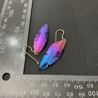 Sale Photo Thumbnail #237: Pair of iridescent leaf or feather-shaped dangle drop earrings featuring vibrant purple, pink, and blue anodized finish with a leaf pattern design. Fitted with wire shepherd hooks. Excellent condition with bright coloring and minimal signs of wear. Each d