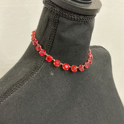 Sale Photo Thumbnail #206: Vintage gold-tone choker necklace featuring round, prong-set vibrant red rhinestones or glass crystals with decorative textured settings. Includes an adjustable hook closure with a rhinestone dangle tail. Appears to be in good vintage condition with all s