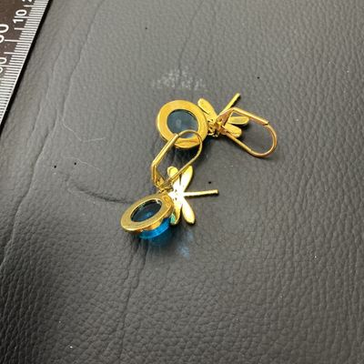 Sale Photo Thumbnail #194: Pair of gold-tone leverback drop earrings featuring a dragonfly accent seated atop round teal-blue glass cabochons. Total length is approximately 35 mm (1.4 inches). Good condition with minor surface wear on metal backs.