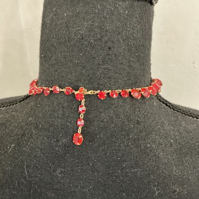Sale Photo Thumbnail #210: Vintage gold-tone choker necklace featuring round, prong-set vibrant red rhinestones or glass crystals with decorative textured settings. Includes an adjustable hook closure with a rhinestone dangle tail. Appears to be in good vintage condition with all s