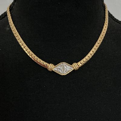Sale Photo Thumbnail #215: Vintage gold-tone herringbone flat chain collar necklace featuring a central diamond-shaped focal point set with clear triangular rhinestones. Stamped S.A.L. © on the back (Swarovski America Limited mark used circa late 1970s to 1980s). Features a fold-o