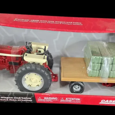 Sale Photo Thumbnail #66: Tomy Big Farm 1:16 scale Farmall 1206 tractor set, featuring a hay wagon and miniature bales, new in original box.