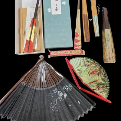 Sale Photo Thumbnail #79: Collection of vintage Asian hand fans, including a large black fan with mother-of-pearl inlay, a boxed fan set, and various folding fans.