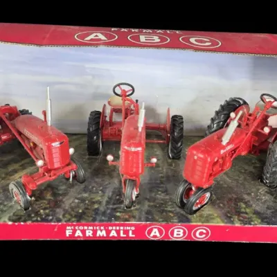 Sale Photo Thumbnail #63: Ertl McCormick-Deering Farmall A, B, and C die-cast metal tractor set in original display packaging.