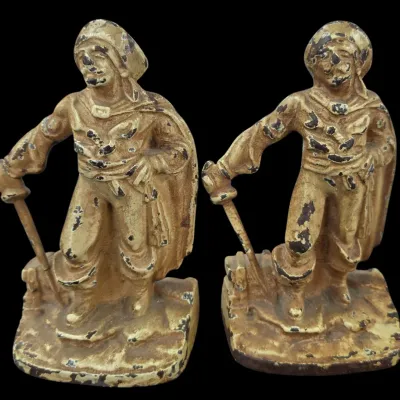 Sale Photo Thumbnail #114: Pair of vintage cast metal pirate-themed bookends with an antiqued painted finish, showing noticeable paint wear and chipping.
