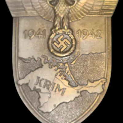 Sale Photo Thumbnail #141: German World War II Crimea Shield (Krimschild) military campaign award, dated 1941–1942, featuring a relief map, eagle, and swastika motif.